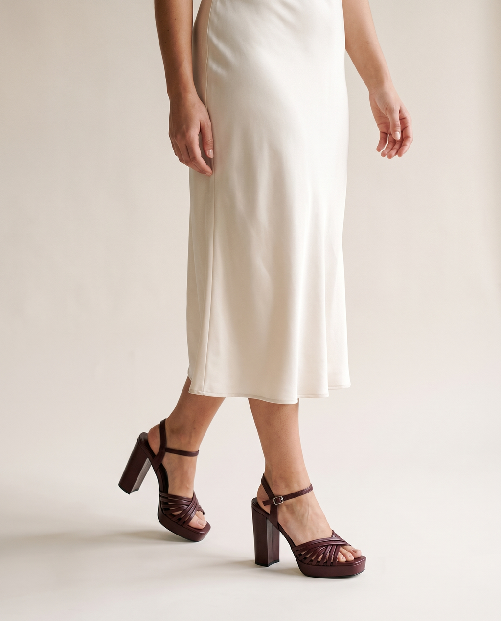 Sagrada sandalia burdeos, puesta con vestido color marfil
