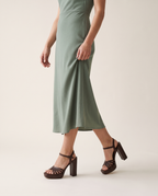 Sagrada sandalia chocolate, puesta con vestido verde salvia